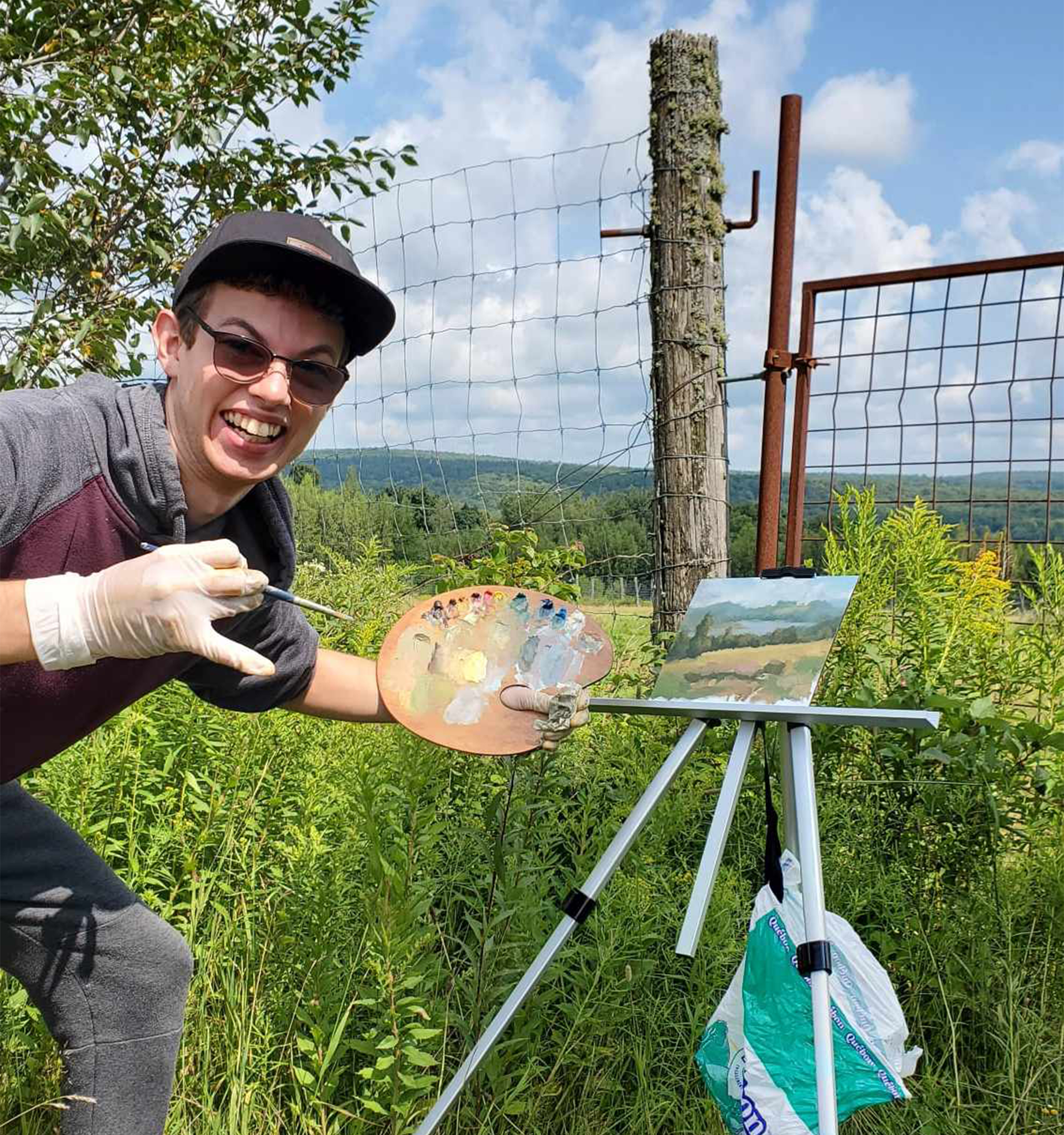 Photographie de Tommy Roy qui peins en plein air.